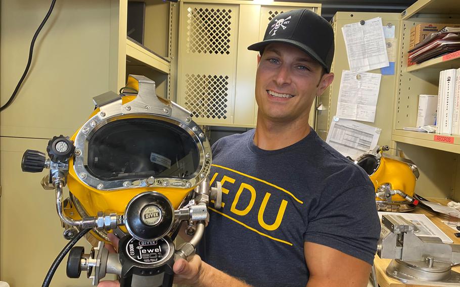 Navy diver Mark Desmarais holds the type of helmet used on the Heaven Can Wait recovery mission, at the Navy Experimental Diving Unit in Panama City, Fla., last September. 