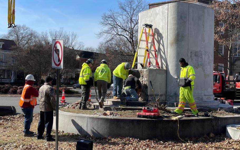 Workers dismantle the pedestal of the Matthew Fontaine Maury statue on Monument Avenue in Richmond, Va., on Tuesday. The city is taking down the remnants of Confederate memorials for the next few weeks.