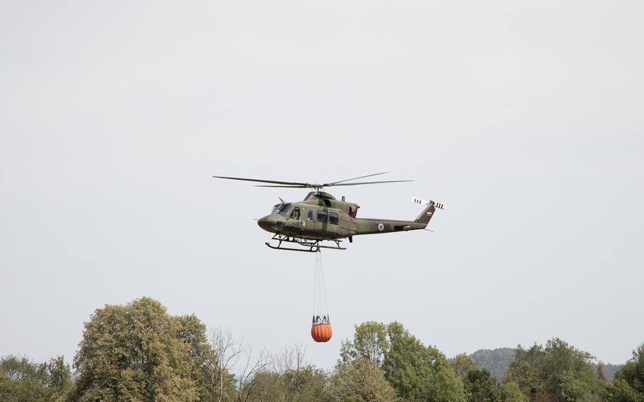 A Slovenian Army helicopter carries water with a bambi bucket to the wildfire near Debni Vrh in Ljubljana, Slovenia, on Aug. 18, 2022. 