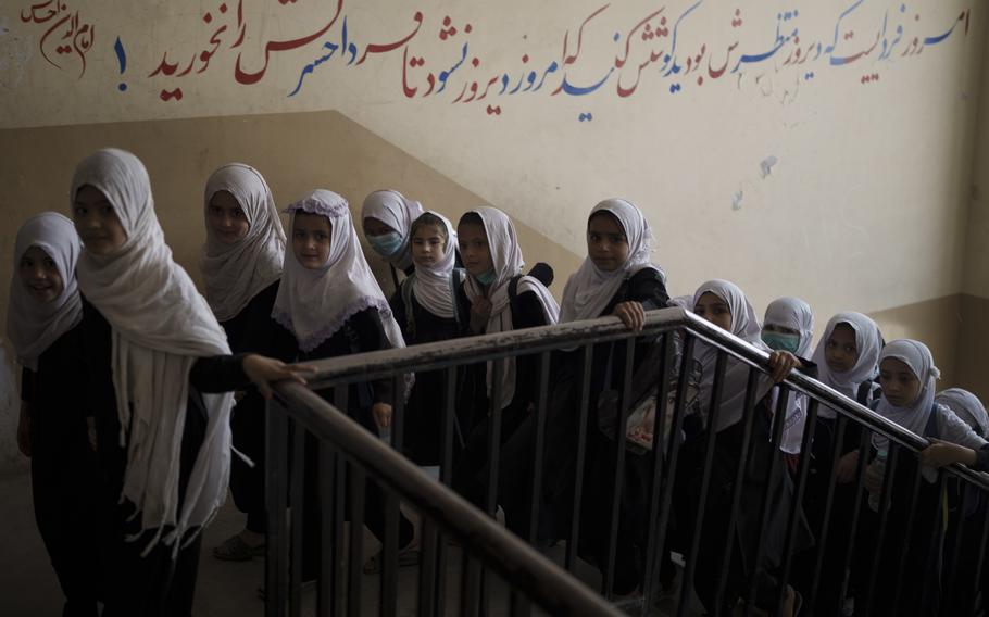 Girls walk upstairs as they enter a school before class in Kabul, Afghanistan, Sunday, Sept. 12, 2021.