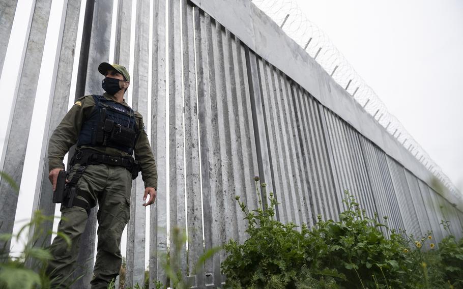 A policeman patrols alongside a steel wall at Evros river, near the Greek village of Poros, at the Greek-Turkish border on May 21, 2021.