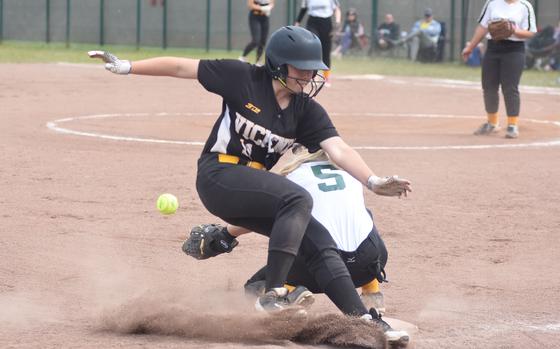 Vicenza's Hannah Findlay slides across third base while Alconbury's Miranda Cowen tries to grab the ball Friday, May 23, 2025, at the DODEA-Europe Division I softball championships at Kaiserslautern, Germany.