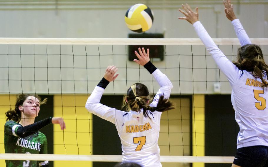 Kubasaki's Adria Lockhart, left, spikes against Kadena's Deniz Dussetschleger and Morgan Sayers during Tuesday's Okinawa volleyball match. The Dragons won in three sets to capture their 18th straight island championship.