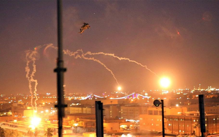 U.S. Army AH-64 Apache helicopters fly over the U.S. Embassy in Baghdad, Iraq, Dec. 31, 2019. The helicopters launched flares the night attackers set fire to the embassy compound. The attacks resulted in $35 million in damage, a State Department Inspector General report said.