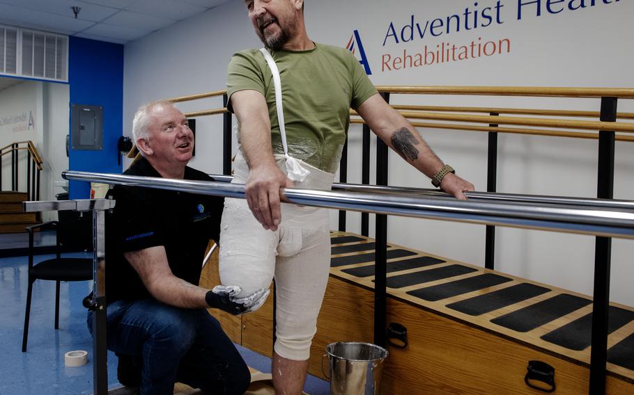 Anatoliy Kirda, one of the Ukrainian soldiers getting replacement limbs at Medical Center Orthotics and Prosthetics in Silver Spring, Md., jokes with Mike Corcoran who is preparing a plaster cast of his leg. 