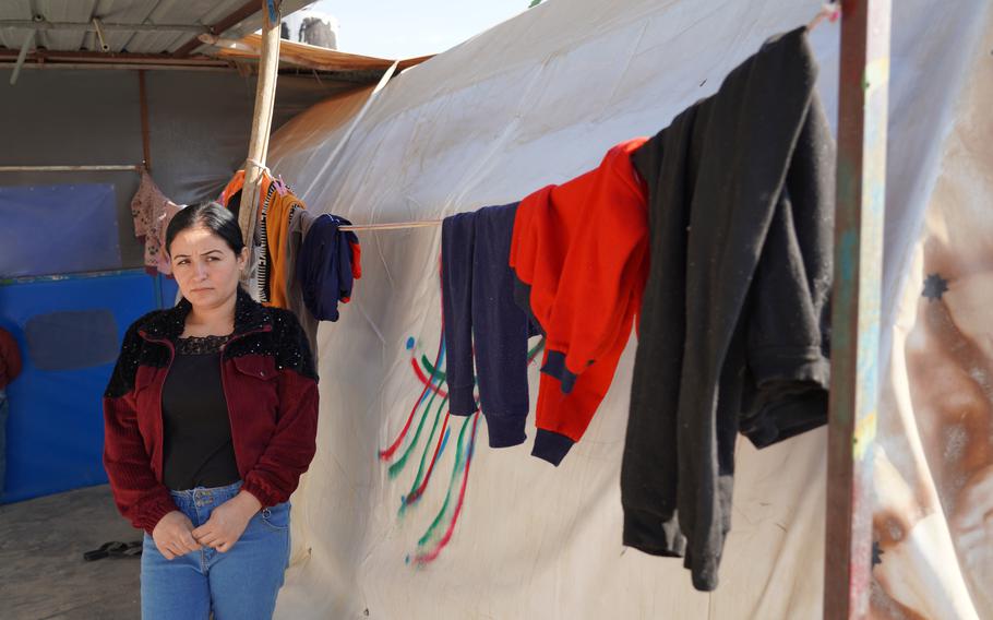Zena Kalo stands outside a tent that her family shares with her sister in law in Kabarto camp in northern Iraq’s Dohuk province on Friday, Nov. 19, 2021. Kalo and her family returned to Iraq from Minsk on Friday two months after they left for Belarus.
