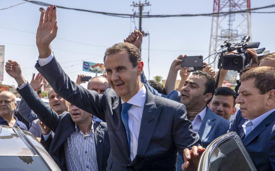 Syrian President Bashar Assad, center, waves to his supporters at a polling station during the Presidential elections in the town of Douma, in the eastern Ghouta region, near the Syrian capital Damascus, Syria, May 26, 2021. President Bashar Assad will head to China later this week in his first visit to Beijing since the country’s conflict started 12 years during which China was one of his main backers, his office said Tuesday. 