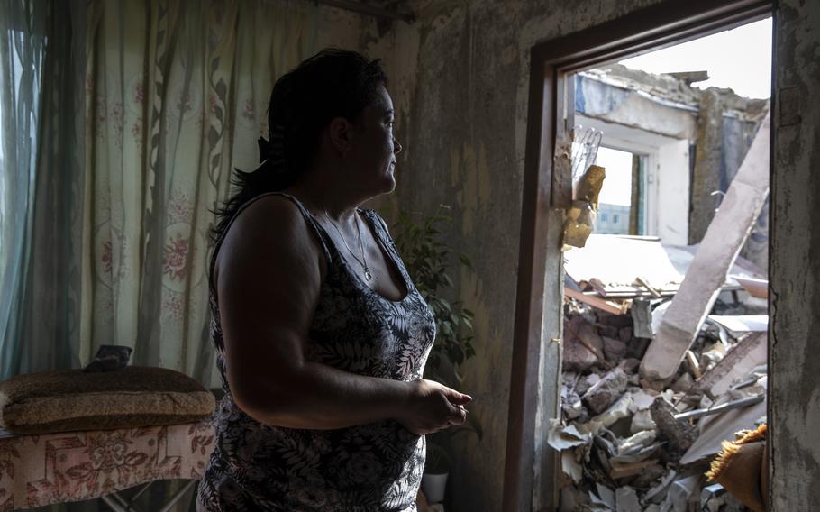 Natalya Khodak, 47, looks at rubble that crashed from above when her apartment building was hit by a Russian strike in Nikopol, Ukraine, on Aug. 12, 2022.