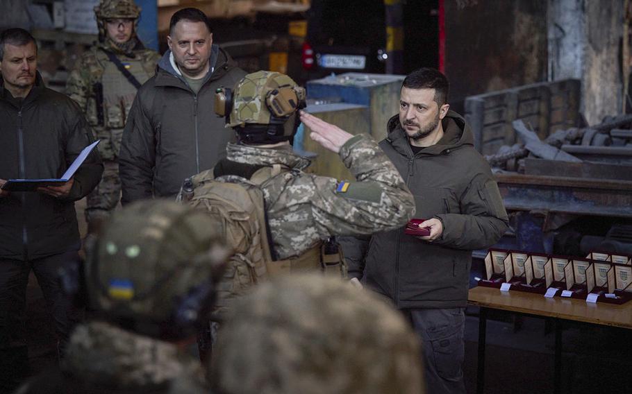 Ukrainian President Volodymyr Zelenskyy, right, awards a serviceman at the site of the heaviest battles with the Russian invaders in Bakhmut, Ukraine, Tuesday, Dec. 20, 2022. 