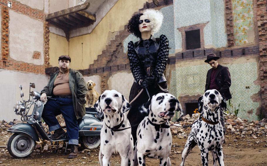 This image released by Disney shows Paul Walter Hauser, from left, Emma Stone and Joel Fry in a scene from “Cruella.”