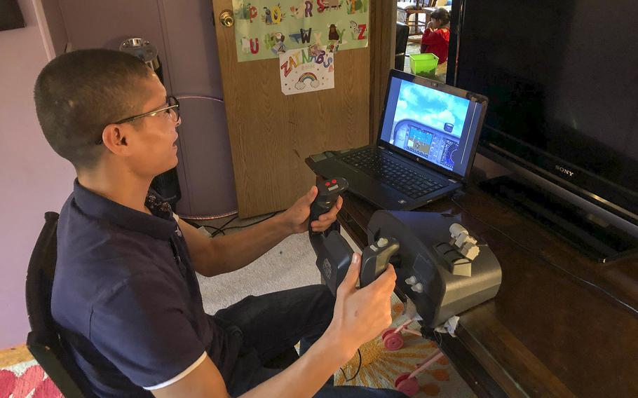 Mohammed Naiem Asadi practices flying with an old edition of Microsoft Flight Simulator at his home in the suburbs of Atlantic City, N.J., Oct. 26, 2021.