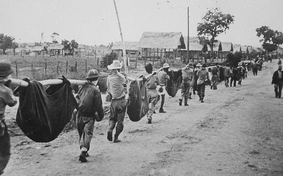 A burial detail of American and Filipino prisoners of war uses improvised litters to carry fallen comrades at Camp O’Donnell, Capas, Tarlac, 1942, following the Bataan Death March.