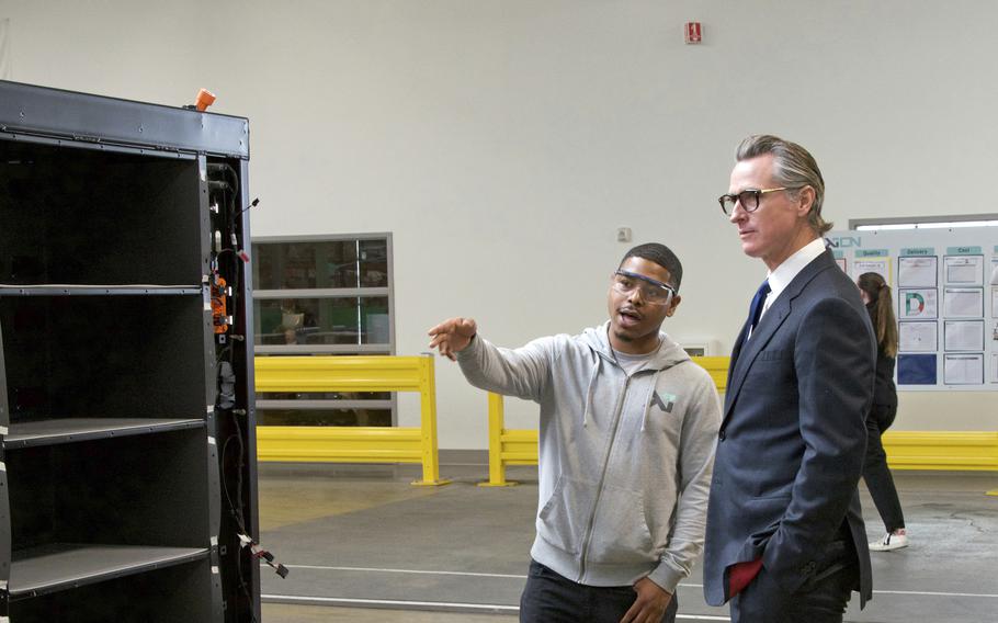In this photo provided by the California Governor's Office, Gov. Gavin Newsom, right, talks to a MOXION employee Thursday, May 25, 2023, in Richmond, Calif. Newsom toured the battery manufacturing plant and touted his updated plan to ease the permitting process for new clean energy projects.
