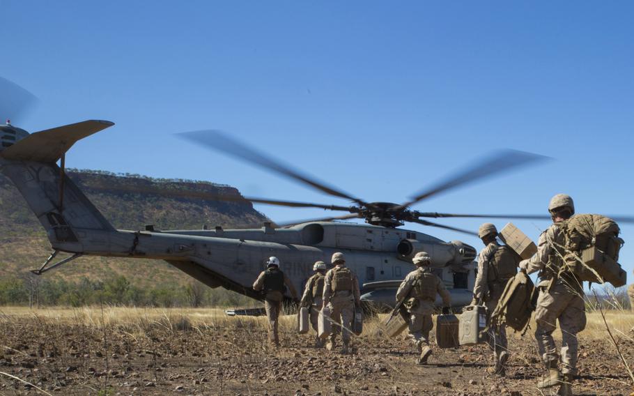 Marines assigned to the 1st Battalion, 5th Marine Regiment rush aboard a CH-53E Super Stallion during Exercise Koolendong in Australia's Northern Territory, Aug. 16, 2021. 