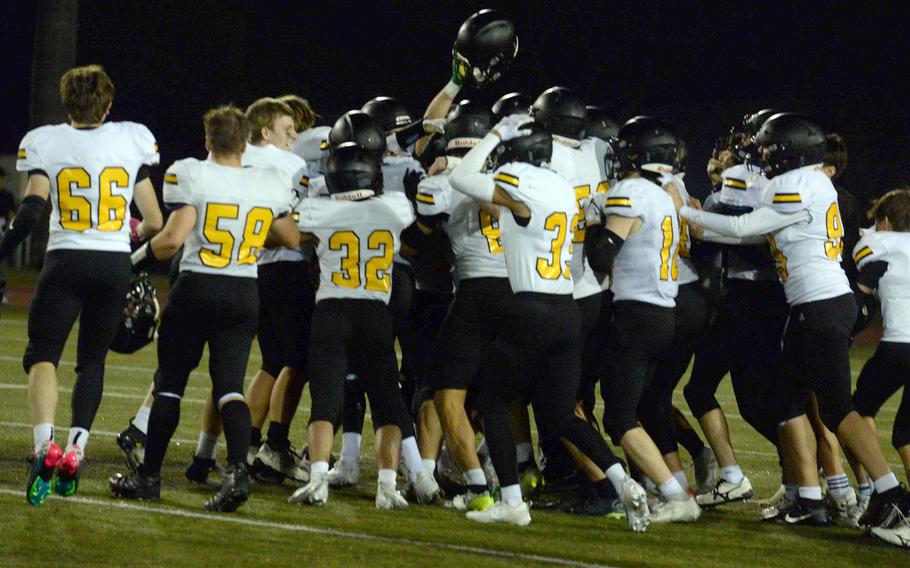 American School In Japan players celebrate their Far East Division II football title.