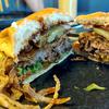 A cheeseburger with fried onions, jalpenos and barbeque sauce.