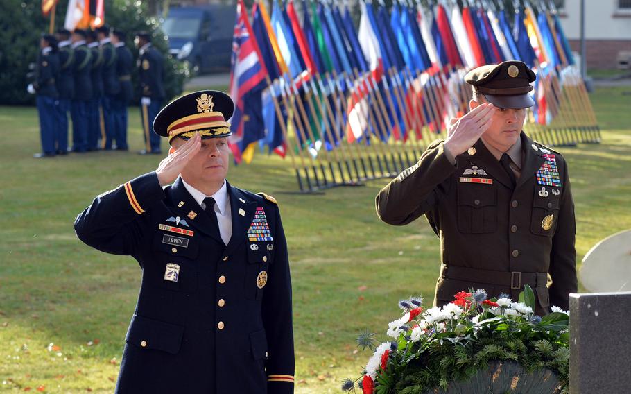 Col. Douglas LeVien, deputy commander of the 21st Theater Sustainment Command, left, and Command Sgt. Maj. Sean Howard salute after placing a wreath Nov. 10, 2021, during the unit’s Veterans Day observance at Panzer Kaserne in Kaiserslautern, Germany.