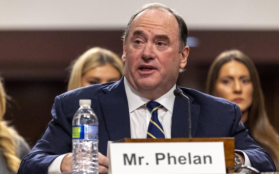 Phelan sitting at a desk speaking.
