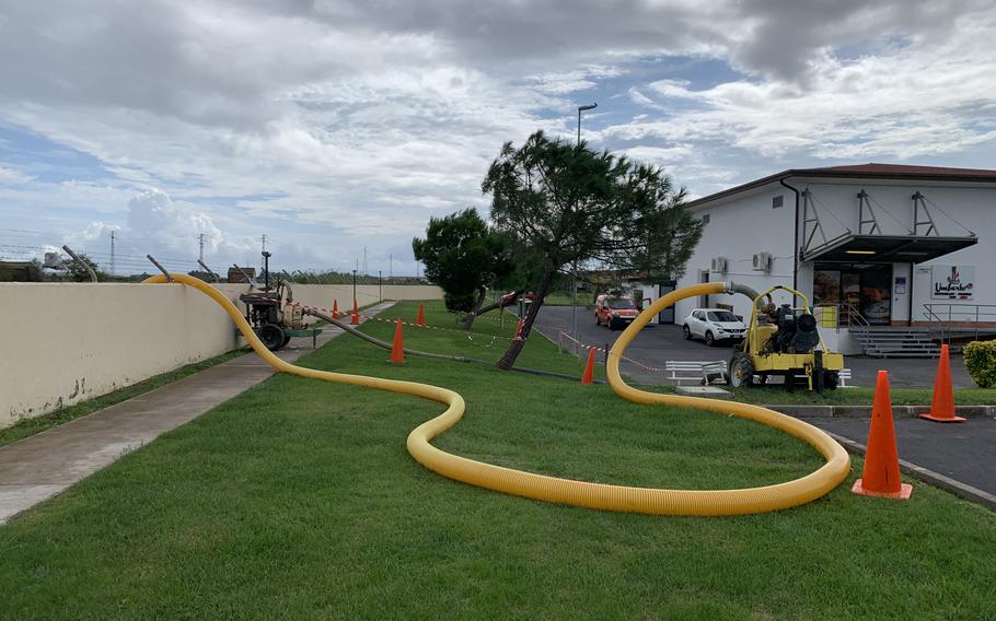 Pumps work on removing water at Marinai housing complex at Naval Air Station Sigonella in Sicily on Saturday, Oct. 30, 2021.