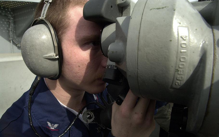 Petty Officer 3rd Class Joseph Burtner identifies ship traffic along the channel leading out of Yokosuka waters Monday, April 15, 2002, as the USS Kitty Hawk departs.  Burtner relayed the information down to the ship’s intelligence department.