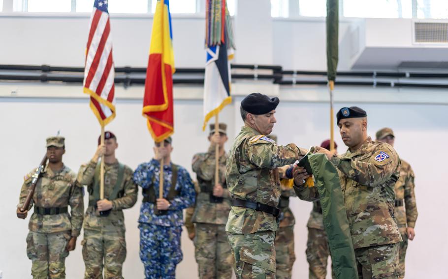 Maj. Gen. Gregory K. Anderson, commander of the 10th Mountain Division, and Sgt. Maj. Jorge Rivera, operations sergeant major for 10th Mountain Division, case the division colors during the transfer of authority ceremony at Mihail Kogalniceanu Air Base, Romania, Dec. 15, 2023.