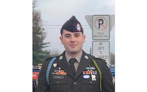 A man in uniform smiles slightly.