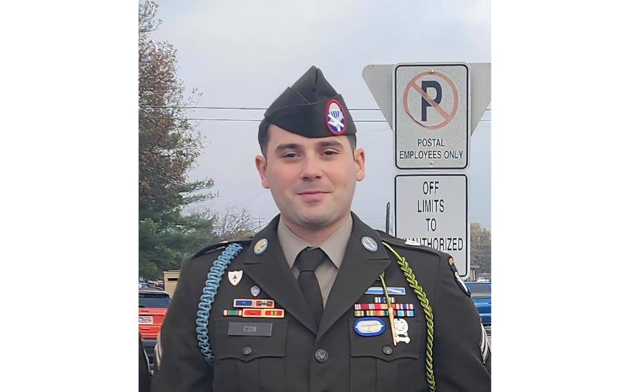 A man in uniform smiles slightly.