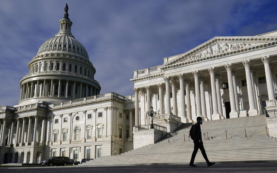 A man walks past the the U.S. Capitol, Wednesday, Oct. 27, 2021, on Capitol Hill in Washington. A $1.5 trillion federal spending bill approved by the Senate on Thursday, March 10, 2022, and on its way to President Joe Biden’s desk will pour $728 billion into the military, funding pay raises for troops, assistance for military families, weapon purchases and other defense expenditures for the fiscal year.