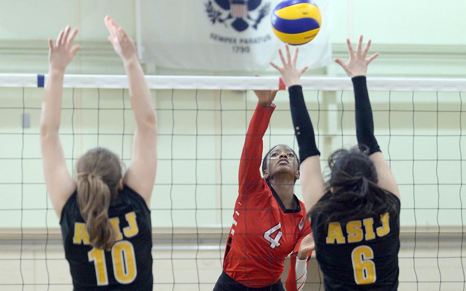 E.J. King's Liz Turner spikes between American School In Japan's Lily Stone-Bourgeois and Sachika Nagaoka during Thursday's pool-play match in the Ryukyu Island Tournament. The Cobras won in straight sets.