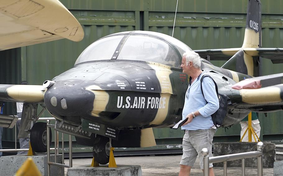 A tourist looks at a U.S Air Force fighter jet used during the Vietnam war.
