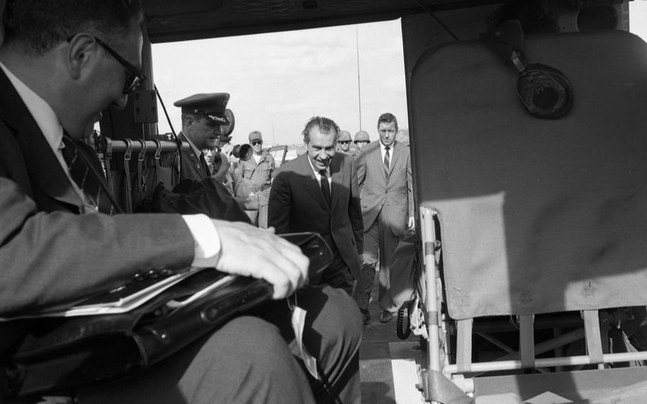 Henry Kissinger, President Nixon’s National Security Adviser, has already taken a seat in the helicopter waiting for his boss to join. President Richard Nixon swept in and out of South Vietnam July 30th during a tour that was mostly kept under wraps as security and secrecy engulfed the Nixon trip as it began from Bangkok without advance announcement. 