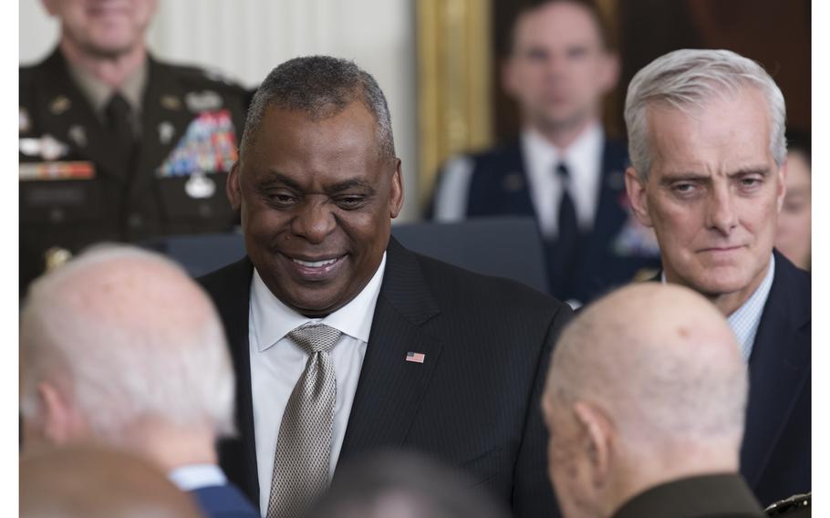 Secretary of Defense Lloyd Austin smiles as retired Army Col. Paris Davis walks beside President Joe Biden upon arriving for a White House ceremony in which Biden presented Davis the Medal of Honor for his heroic actions in Vietnam nearly 58 years ago. Looking on at right is Secretary of Veterans Affairs Denis McDonough.