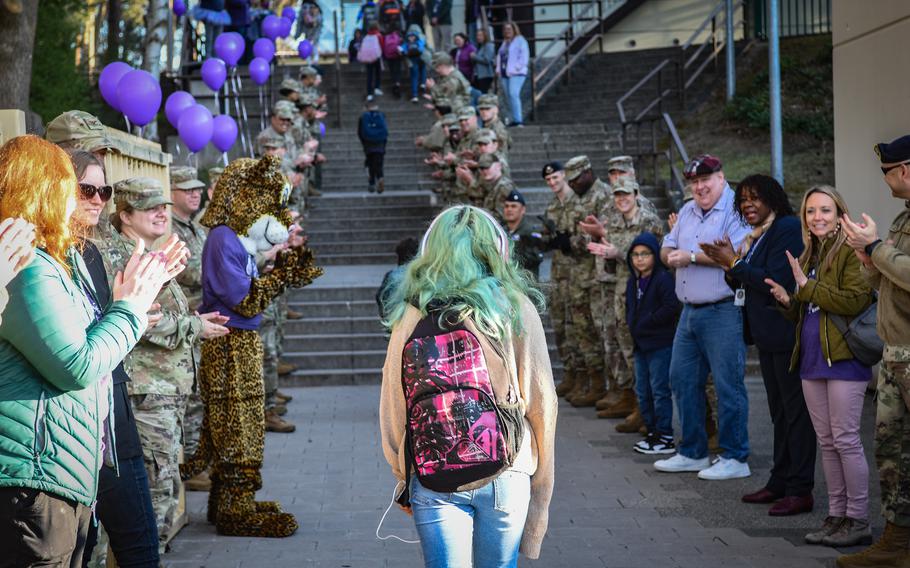 Service members, parents and school staff members greet children as they walk up the stairs to Ramstein Intermediate School at Ramstein Air Base, Germany, on April 19, 2022. The outsized welcome was part of the school’s celebration for Month of the Military Child. 