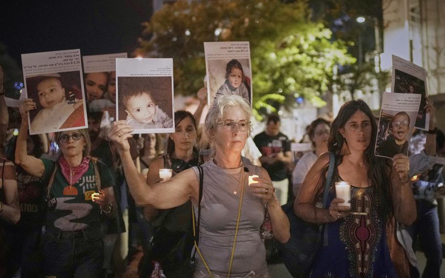 Israeli protestors hold pictures of Palestinian children killed during Israel’s military operation in the Gaza Strip.