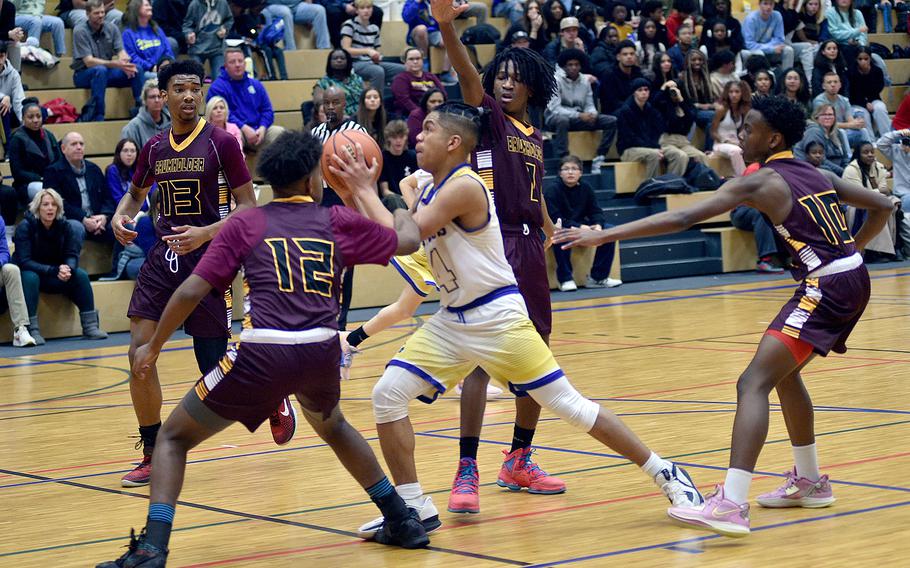 Nigel Rodriquez, center, drives between four Baumholder defenders, from left, Caleb Piggé, Jaylen Velasquez, Leo Kirkland and Davion Haywood on Friday at Wiesbaden High School in Wiesbaden, Germany.