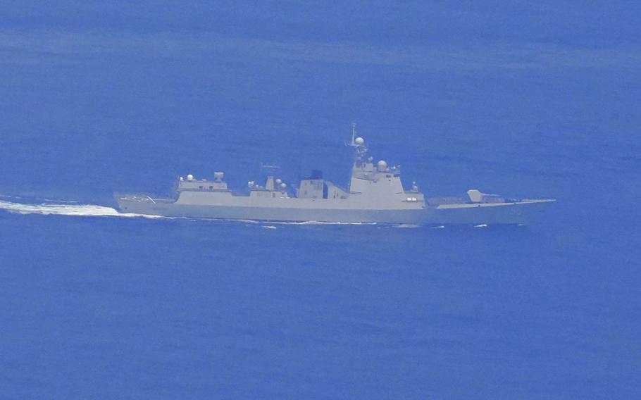 A Chinese naval ship, seen from above at a distance, travels through open water.