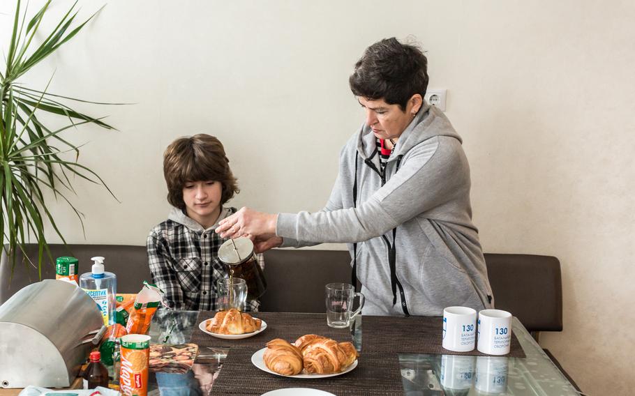 Maryana Zhahlo, 52, pours tea for her 12-year-old son Lev at home in Kyiv, Ukraine on Jan. 23, 2022. Maryana, a mother of three, marketing analyst, joined the 130th territorial defense battalion and last spring when there was a threat of a full-scale Russian invasion, bought the rifle and attended the sniper school course. The Territorial Defence Units are part of the Armed Forces of Ukraine and consist of people, who mostly also have regular jobs that they do during a week. 