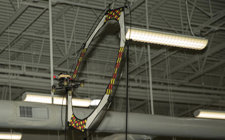 A drone is flown through a ring hanging high in the air.
