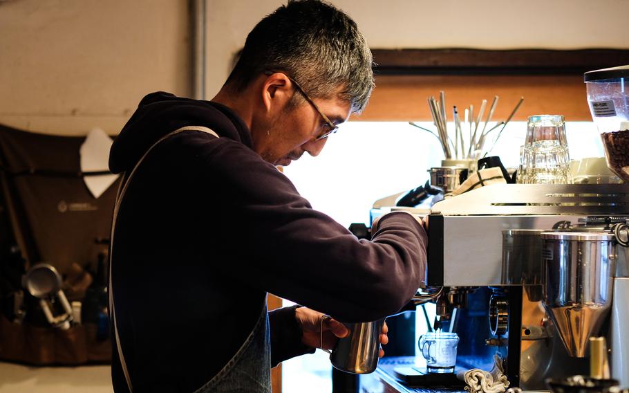 Megumu Gomi, co-owner of Cafe D-13, makes a latte in his shop near Yokota Air Base, Japan.