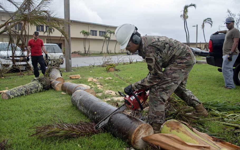 Master Sgt. John Paul Diaz, the 36th Wing's safety superintendent, cuts up a tree downed by Typhoon Mawar at Andersen Air Force Base, Guam, Tuesday, May 30, 2023.
