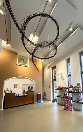 A swirling sculpture hanging from a whilte ceiling