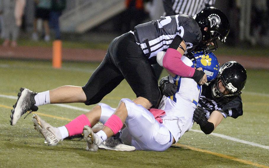 Zama's Connor Lape and Kainoah Venn bring down Yokota quarterback Dylan Tomas for one of three sacks.