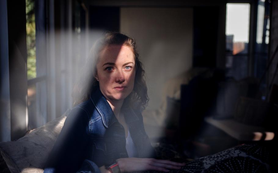 Alison Sbrana, who struggles with fatigue and brain fog after having mono several years ago, sits on a screened-in patio at her home in Fort Collins, Colo., on Nov. 3, 2021. 