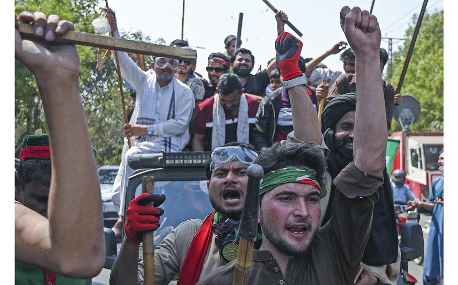 Supporters of former Pakistan’s prime minister Imran Khan shout slogans as they march towards Khan’s residence in Lahore on March 16, 2023.