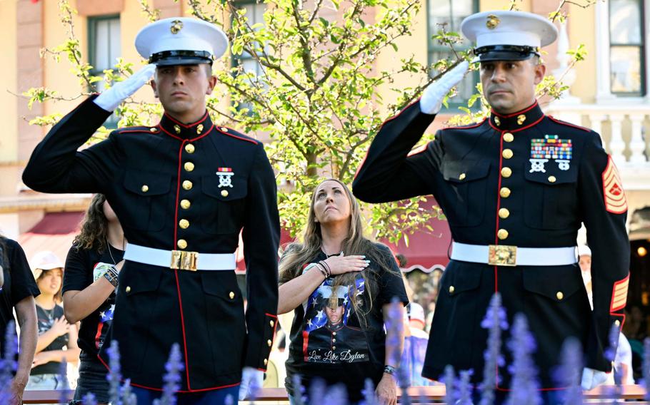 Cheryl Rex, center, stands as the flag is lowered with her son, Marine Private Branden Murrell, left, and Master Sergeant Patrick Hause, during the flag retreat at Disneyland in Anaheim, CA, on Monday, August 8, 2022. 