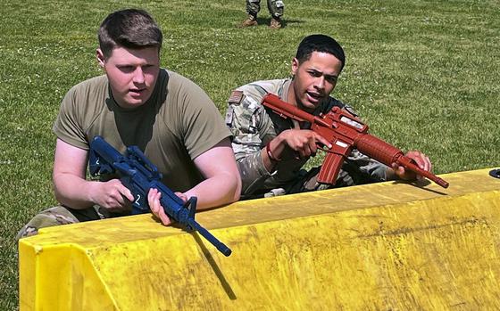 Airman 1st Class Hayden Smith and Senior Airman Kalyn Bake of the 374th Security Forces Squadron take cover during a fire team challenge at Yokota Air Base, Japan, May 17, 2023. 