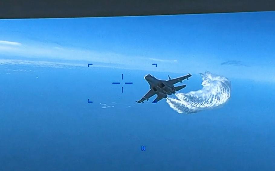 This screenshot is from a video released by U.S. European Command showing one of two Russian fighter jets buzzing past a U.S. drone over the Black Sea on Tuesday, March 14, 2023. One of the Russian jets later collided with the U.S. aircraft.