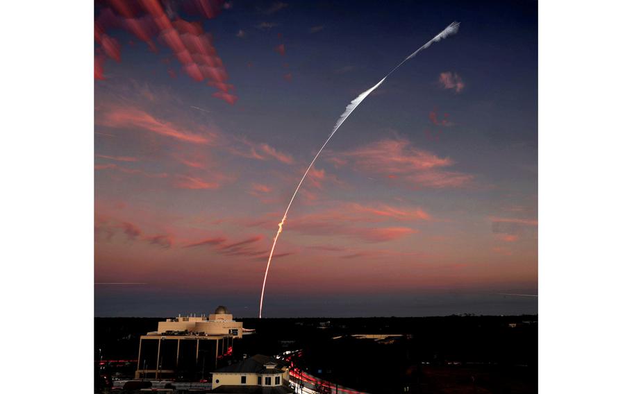 A time-lapse image shows the trajectory of the SpaceX Falcon 9 rocket lifting off from Cape Canaveral Space Force Station over the Orlando Science Center observatory at dusk, Jan. 31, 2022. 