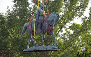 A statue of Confederate Gen. Robert E. Lee in Charlottesville, Va., is lifted off its pedestal in July 2021. 
