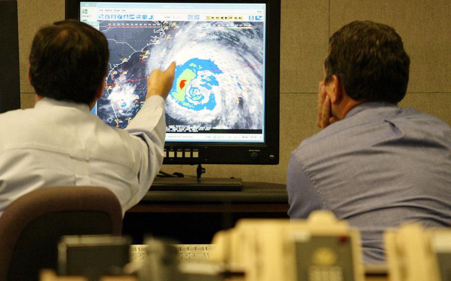 Hurricane forecaster James Franklin (L) and Dr. Richard Pasch discuss Hurricane Isabel at the National Hurricane Center in Miami, Sept. 17, 2003. Isabel was on a path that would bring it ashore on Sep.r 18 on the North Carolina coast, then north along the Chesapeake Bay near Washington D.C., through Virginia, Maryland and Pennsylvania, the U.S. National Hurricane Center said.